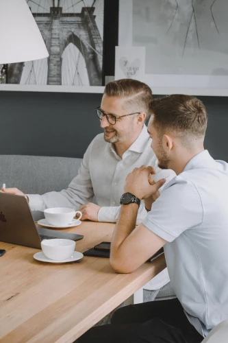 Geschäftsführer und Auszubildender am Tisch mit Kaffee